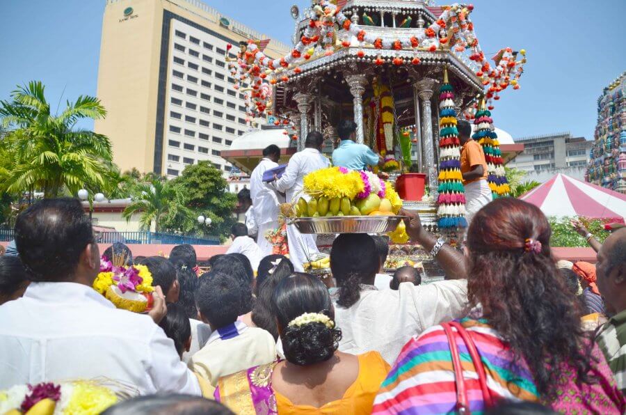 People line up to give offerings to and receive blessings from the chariot.