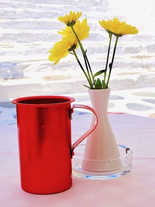 Quatruzzo, red copper decanter for wine next to flowers