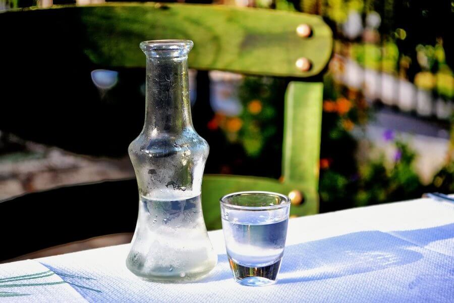 A shot and a small bottle of ouzo