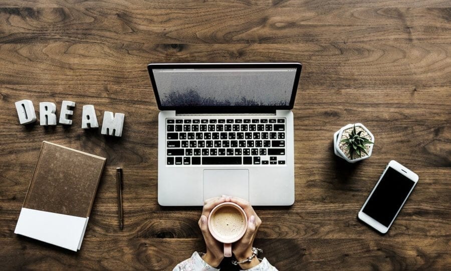 Girl holding coffee, working on computer