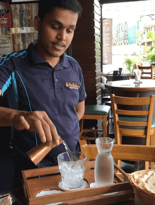 Server pouring a drink at Olive-where to eat in penang