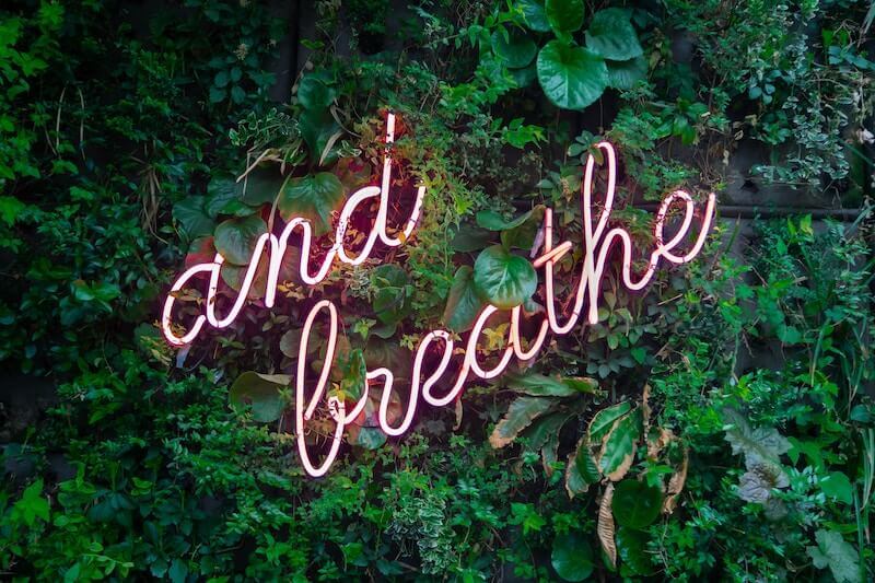 pink neon sign "and breathe"