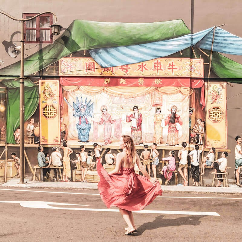 Girl in red dancing in front of street art: How to be an expat