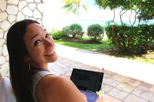 Girl with laptop looking at ocean