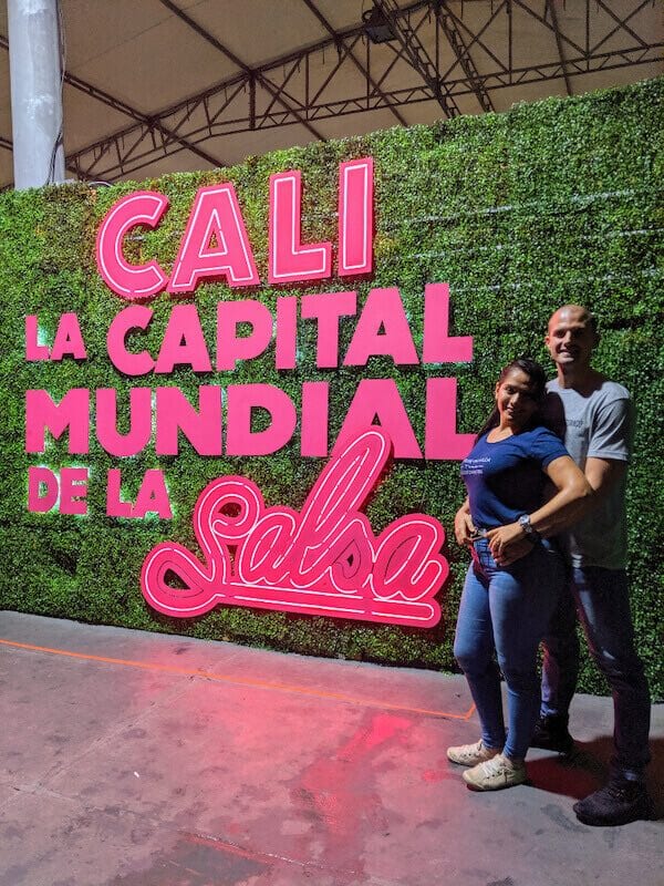 Couple standing in front of pink sign 