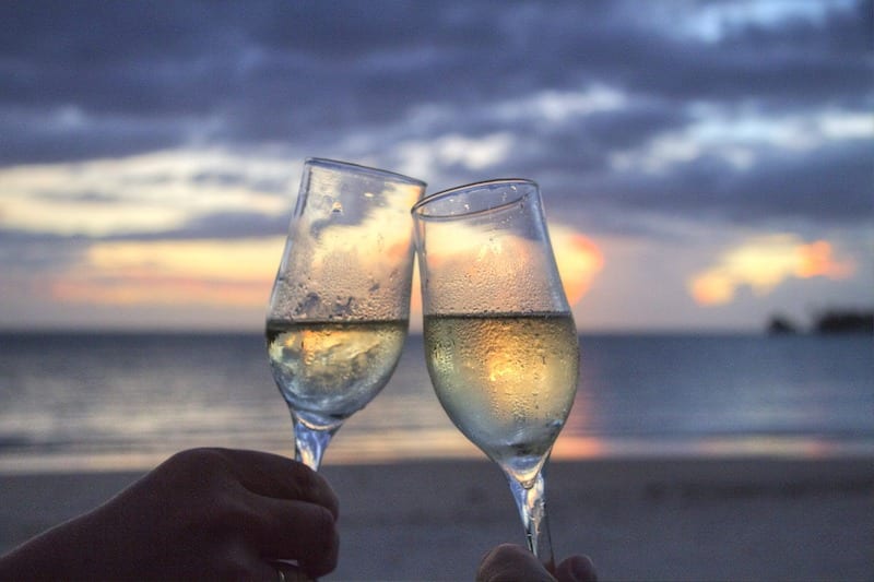 2 champagne glasses toasting. Dos and Don'ts in Malaysia