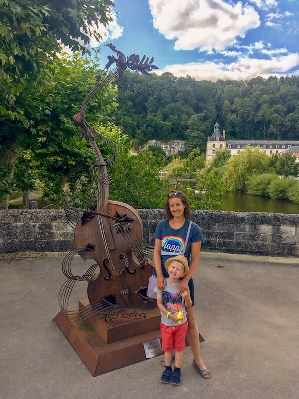 Mom and son posing in front of sculpture of cello: multicultural kids