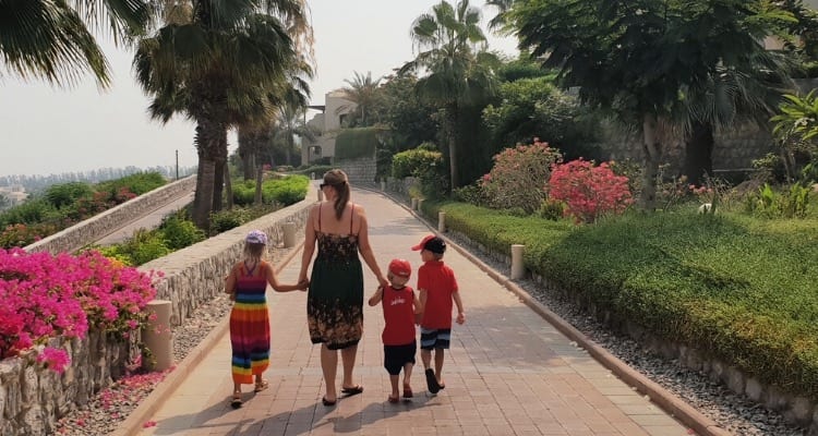 woman walking with kids down a path: multicultural kids