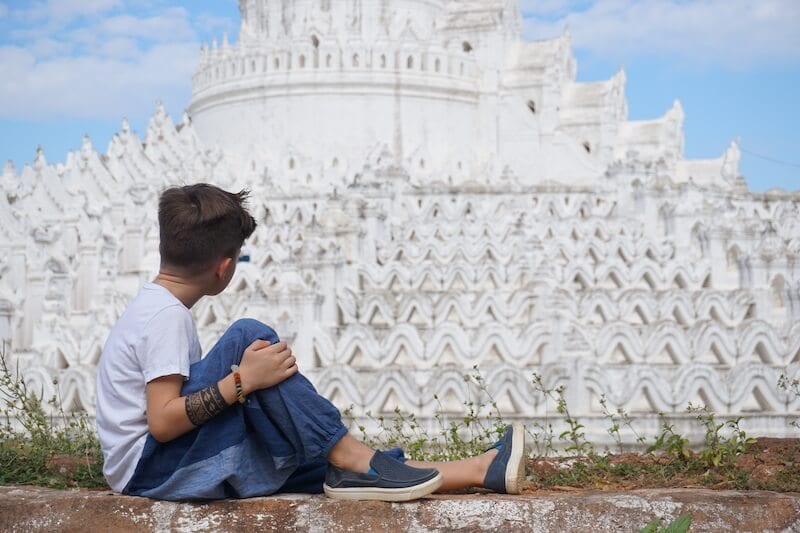 boy staring at white temple in Thailand: multicultural kids