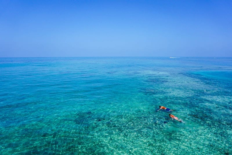 snorklers in clear blue water 