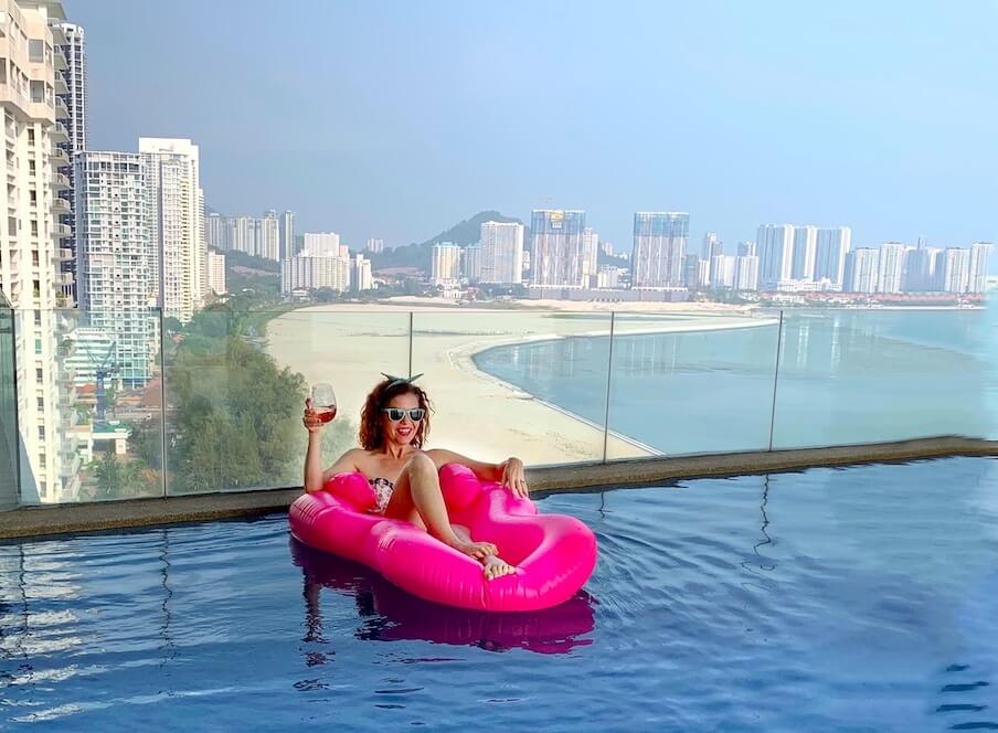 me in pool with pink floatie, penang in background