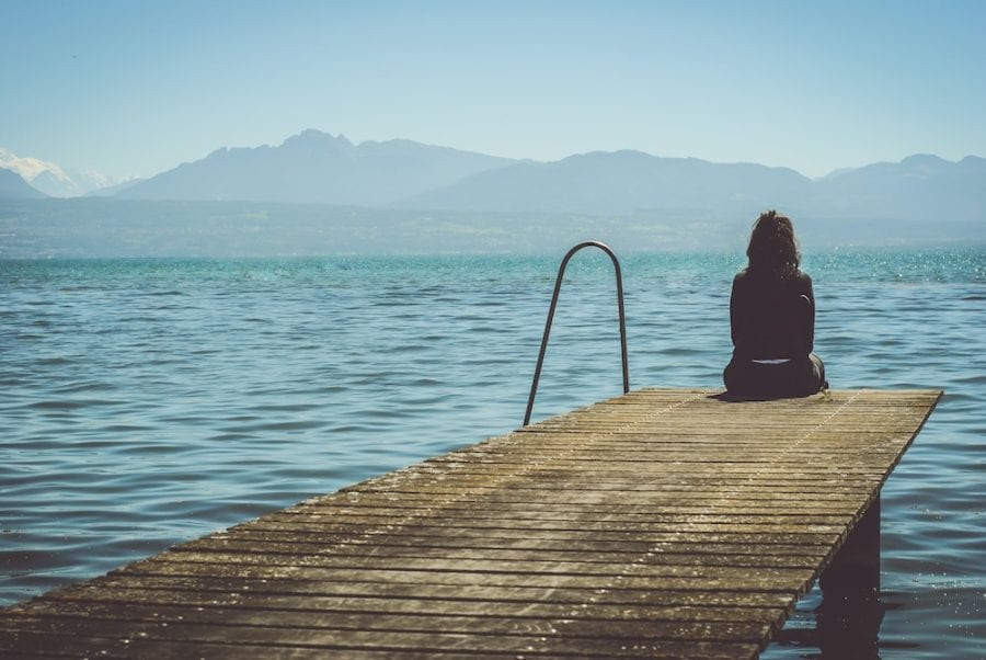 girl sitting on pier-moving away from family