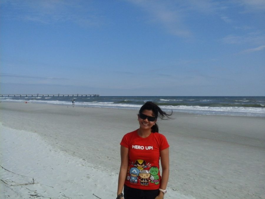 Ruby, a girl in a red t-shirt standing in front of a Florida beach