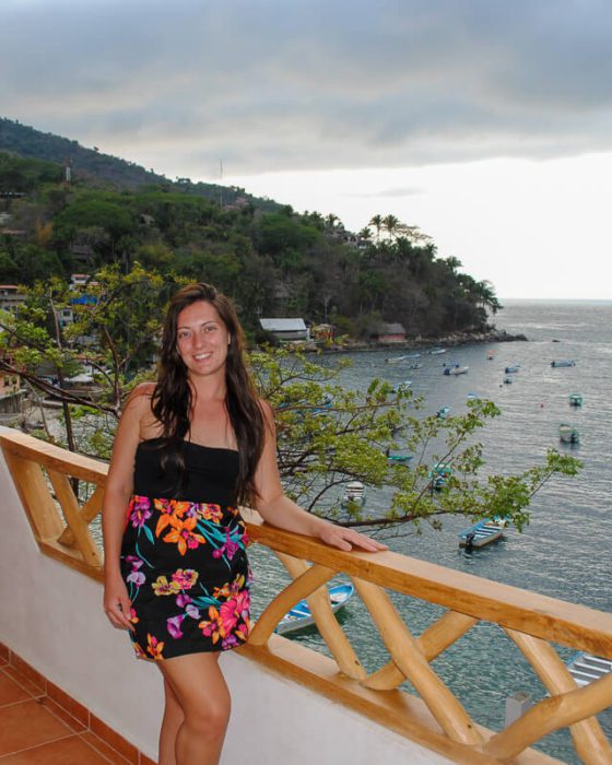 Heather in a floral dress on a balcony over the ocean: reasons to move to another country