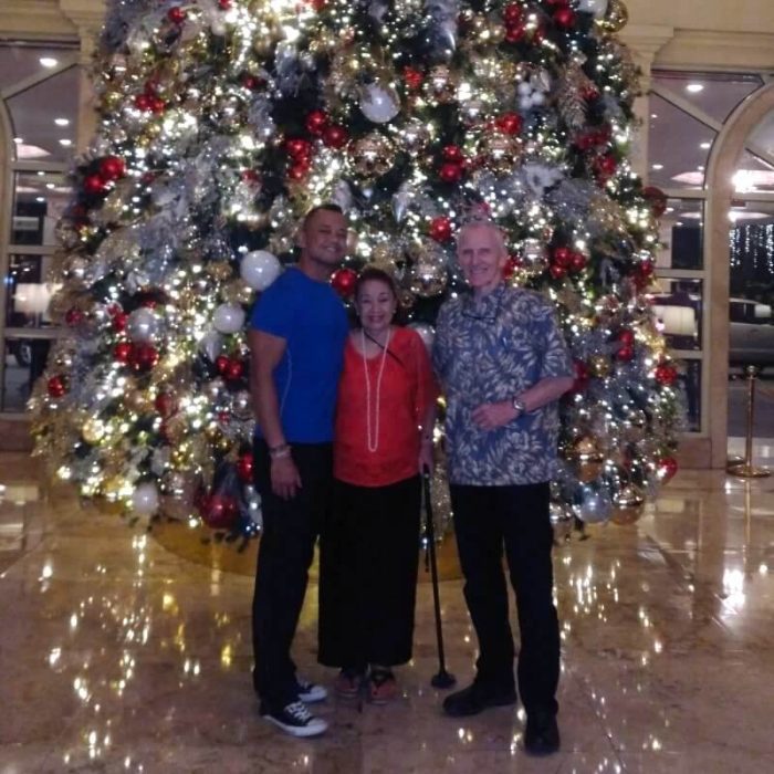 3 people in front of Christmas tree