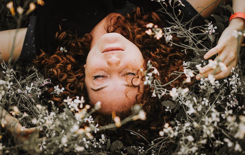 redhead laying in the flowers: move away from family