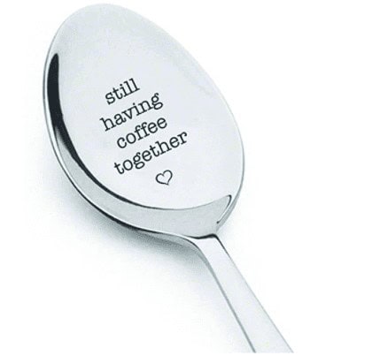 spoon engraved with, "still having coffee together" with a heart under the words. a perfect going away gift