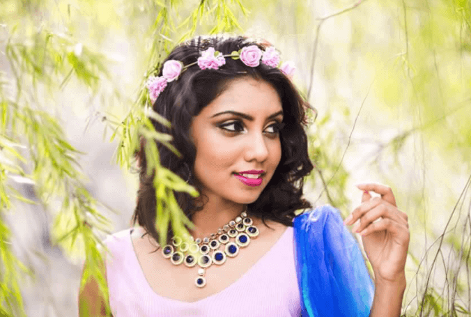 malaysian woman with pink dress and flowers in her hair in nature
