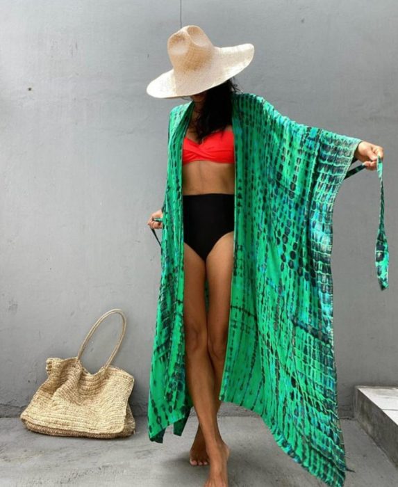 woman with hat and bikini modeling a green tie dye kimono