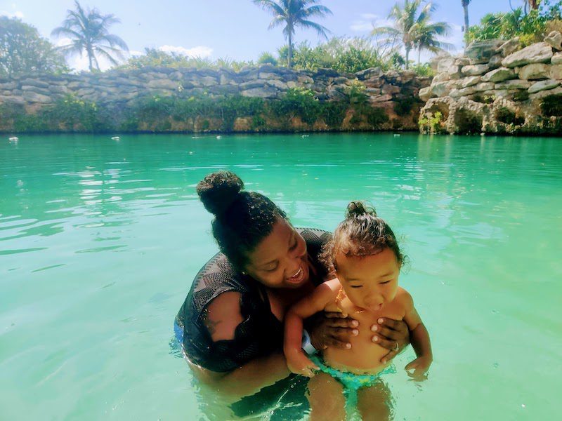 woman in the beautiful green water with a baby: happy nomad family