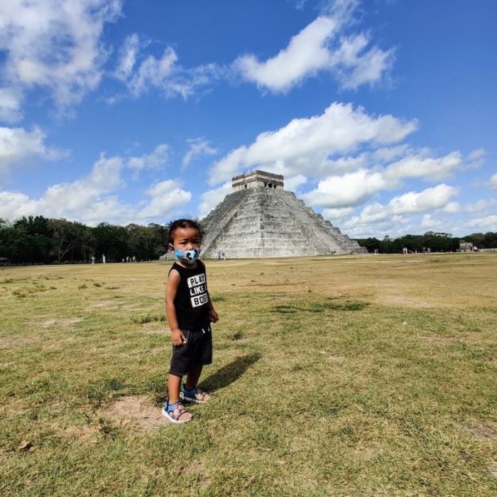 little boy in front of Chichen Itza pyramid in Mexico 