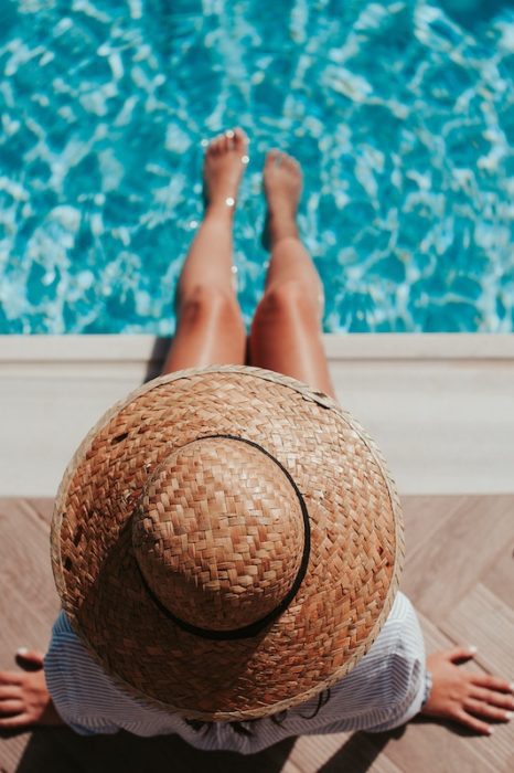 girl with hat by pool 