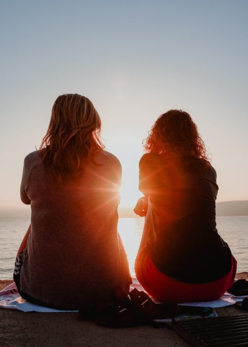 girls sitting on the beach 