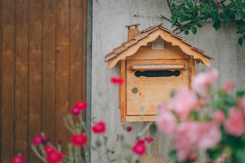 wooden mailbox surrounded by flowers