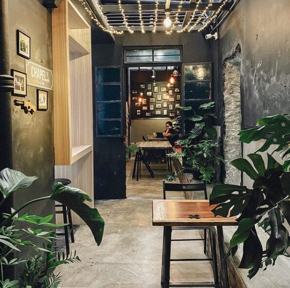 Interior of the Chapel Street Penang Cafe. Cement floors with loads of plants and wood touches. 