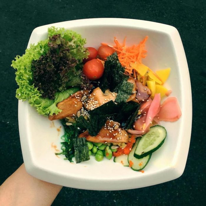 poke bowl with salmon, cucumbers, carrots, ginger, nori, lettuce
