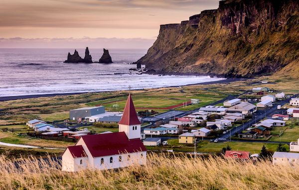 Small village and red rooftop church by the coast in iceland.