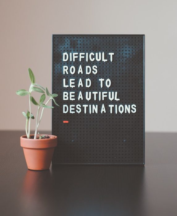 a sign reading "difficult roads lead to beautiful destinations"