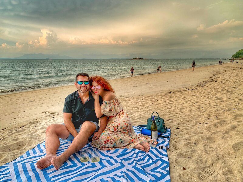 couple siting on a blanket on the beach