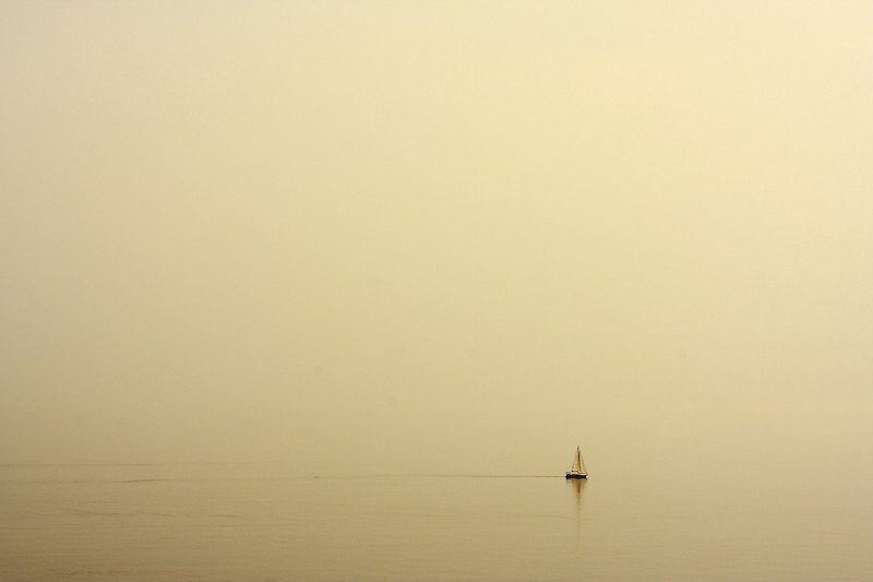 lonely sailboat on a yellow background