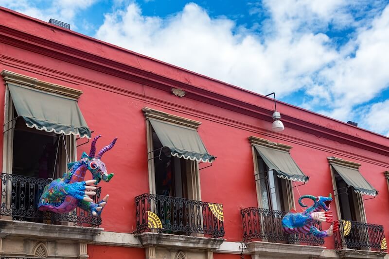 Alebrijes in a balcony in Oaxaca, one of the best cities to live in Mexico