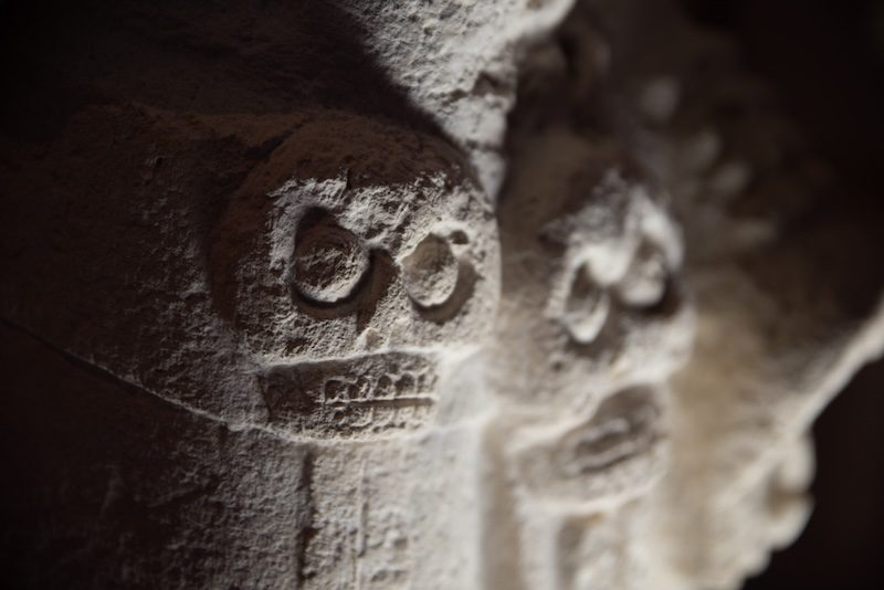 Detail of skulls carved on a stone in Merida, Mexico.