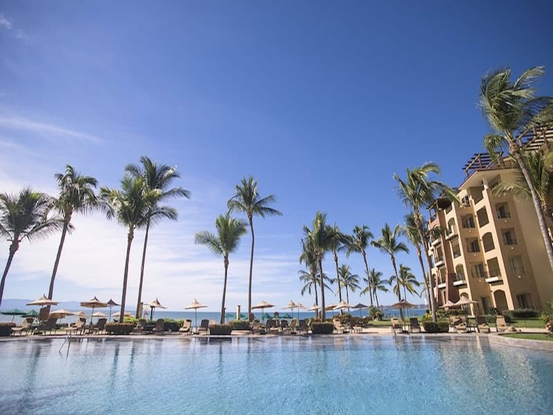 Tall palms, pool and ocean view at Villa Estancia Hotel in Puerto Vallarta