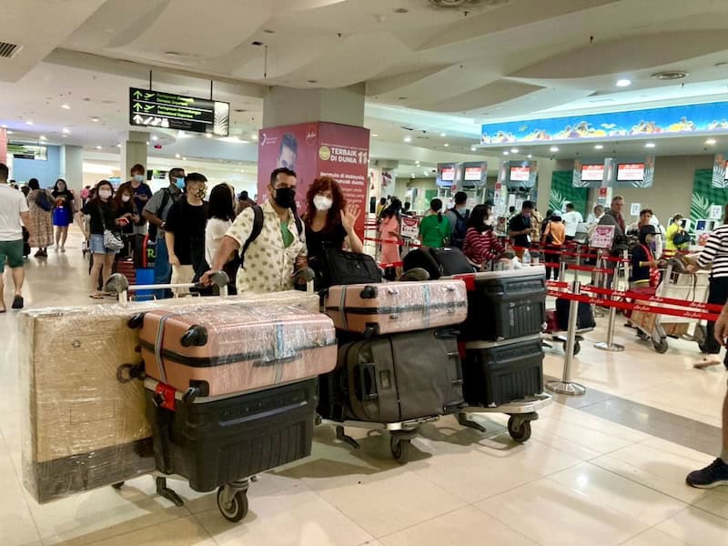 couple with luggage at airport before moving abroad