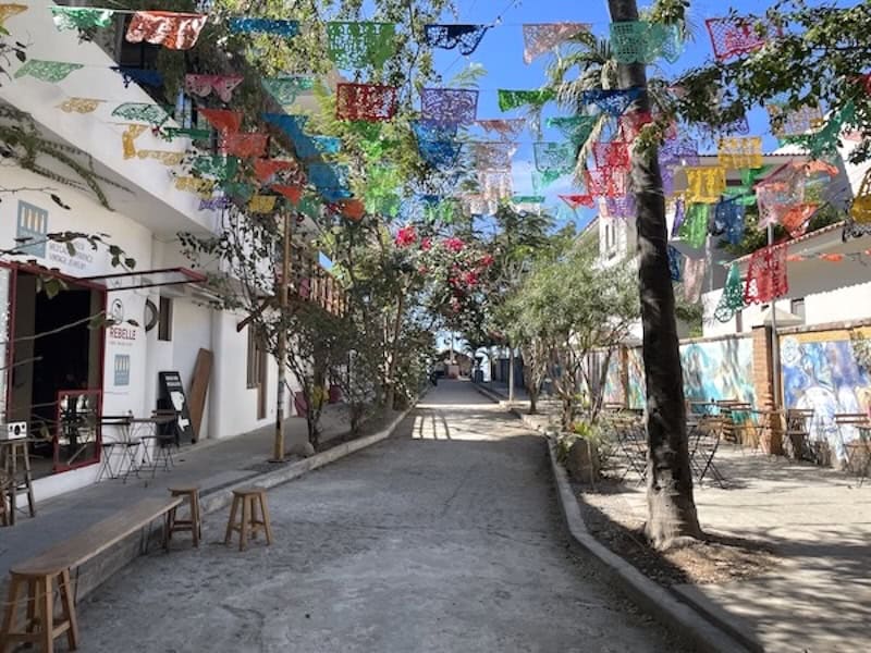 colorful flags above a narrow alley in San Pancho Nayarit