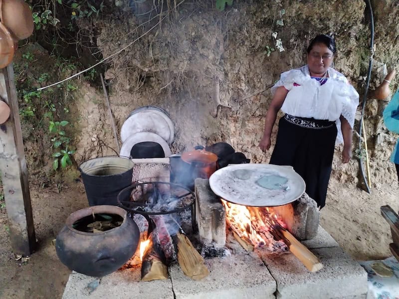 mama next to a comal and fire in Zacatlan Mexico