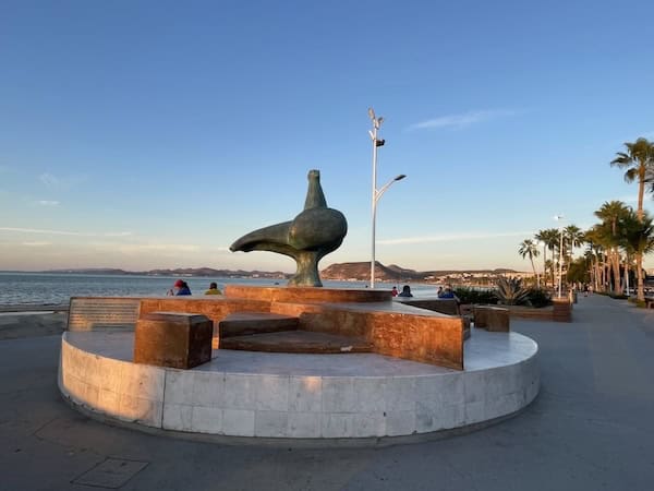 Malecon statue and walkway lined with palms in La Paz, Mexico
